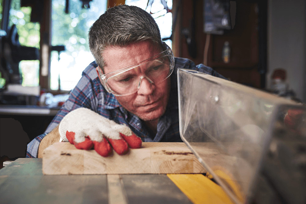 A man Cutting wood on a table saw A man Cutting wood on a table saw