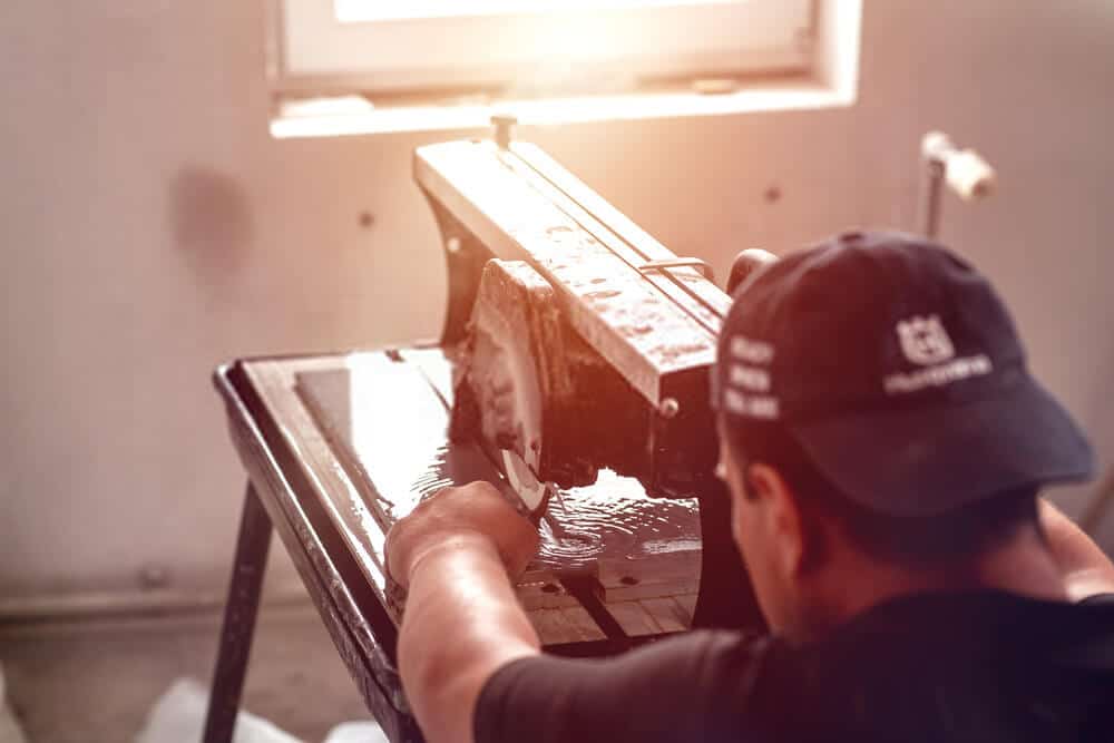 wet saw machine Man cutting tile on wet saw machine