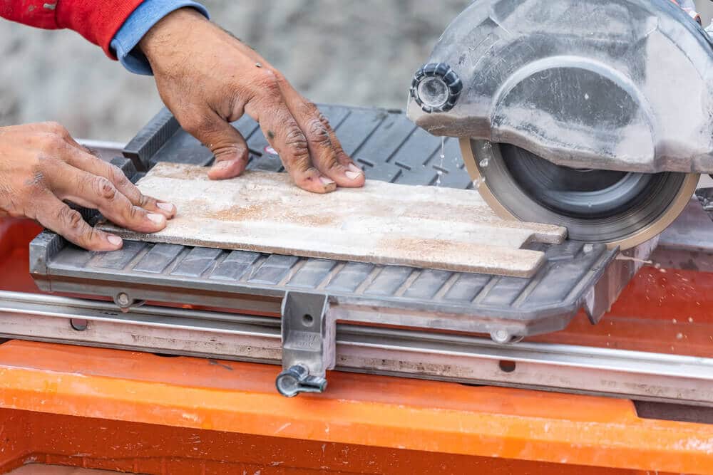 Wet Tile Saw to Cut Wall Tile Worker Using Wet Tile Saw to Cut Wall Tile
