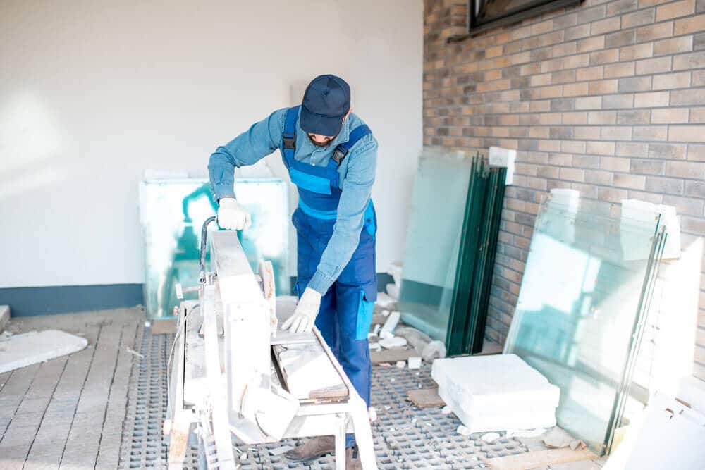 Man cutting tiles with big Tile Cutter on the construction site outdoors Man cutting tiles with big Tile Cutter on the construction site outdoors