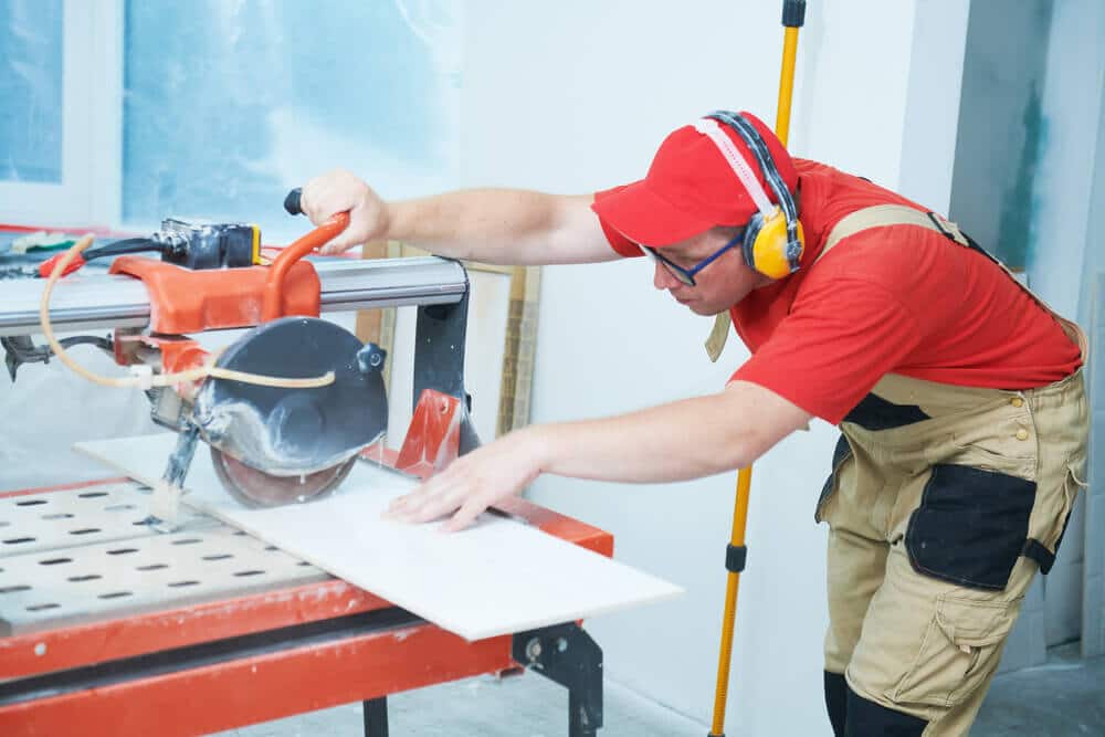 Man oparate a wet tile saw machine to cutting tile A man oparate a wet tile saw machine to cutting tile