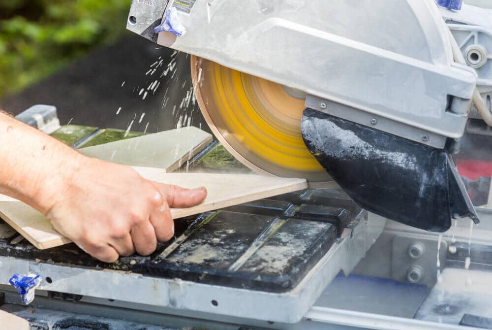 Tiler cutting tile on a tile cutting machine Tiler cutting tile on a tile cutting machine