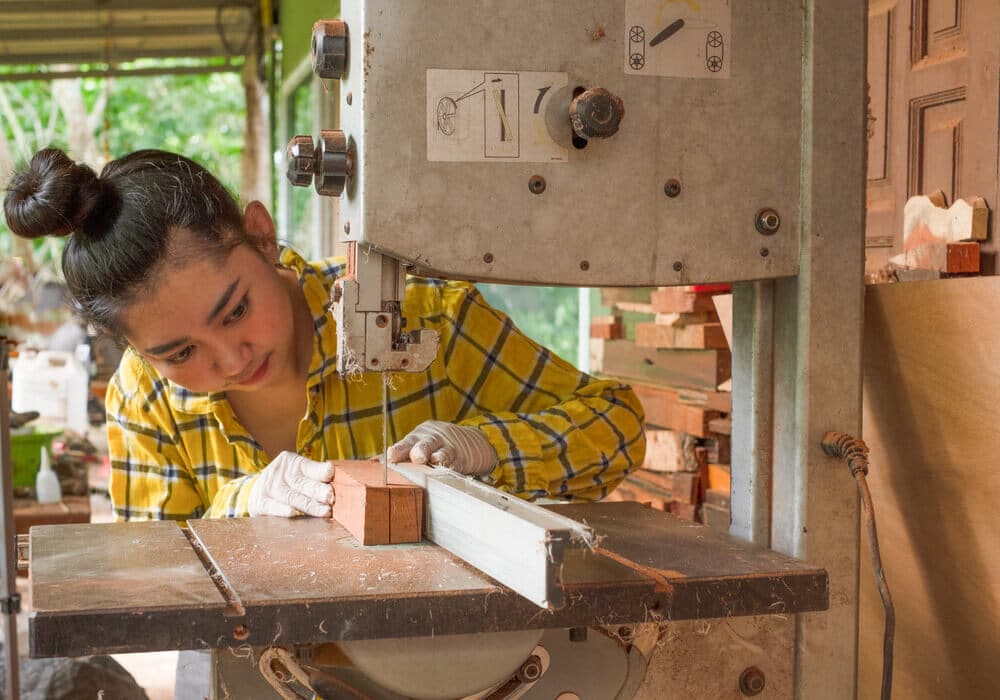 Resawing A women working cut wood at a work bench with Resawing band saws