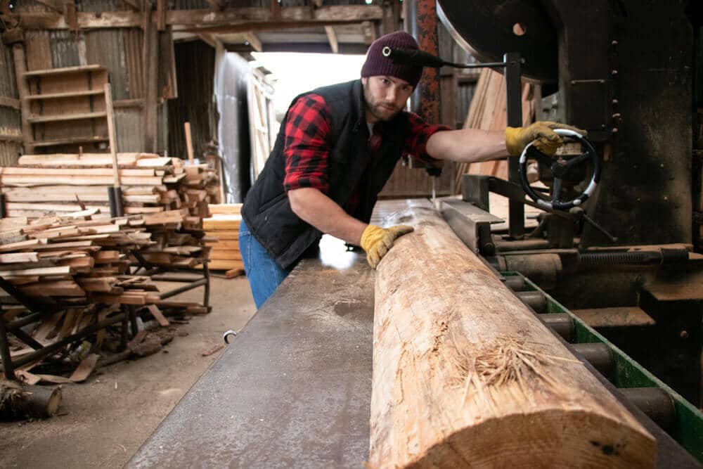 wood-cutting-with-band-saw woodworker cutting straight wood block using band saw
