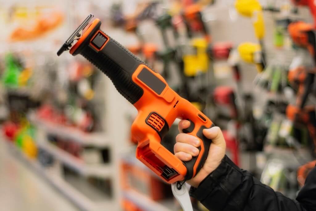 reciprocating-saw Man holds a modern reciprocating saw