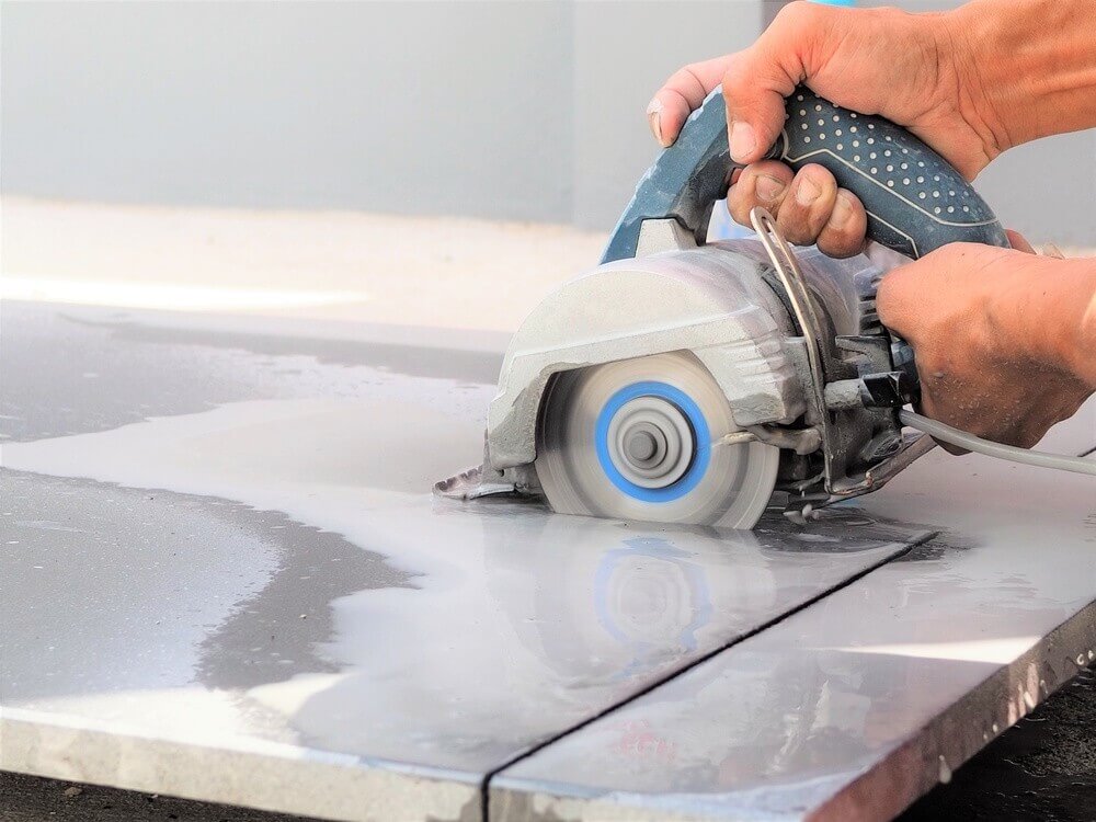 hand-tile-saw worker use wet hand sawing machine for cutting marble stone
